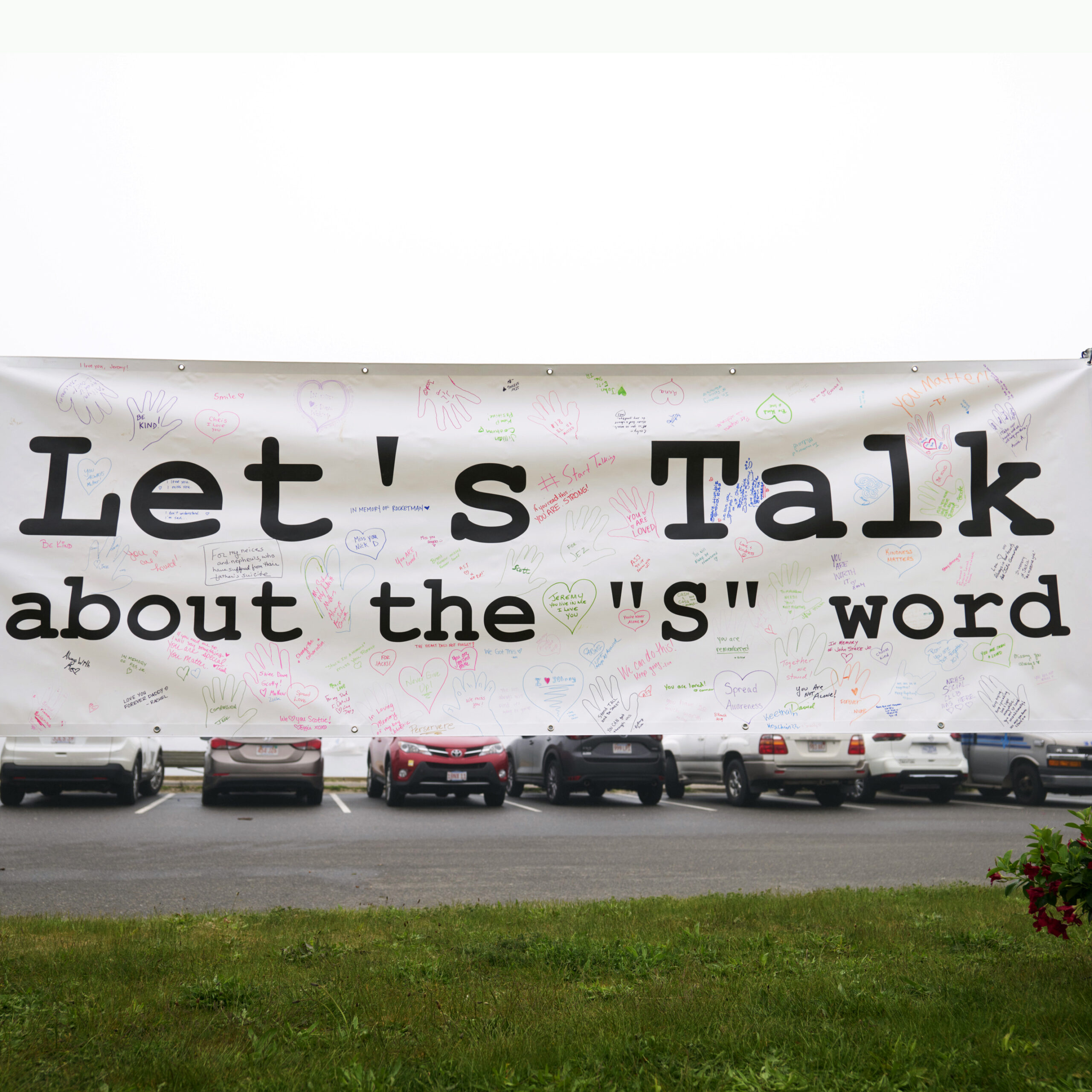 Image of a sign at the Suicide Awareness Walk that says, "Let's talk about the 's' word."